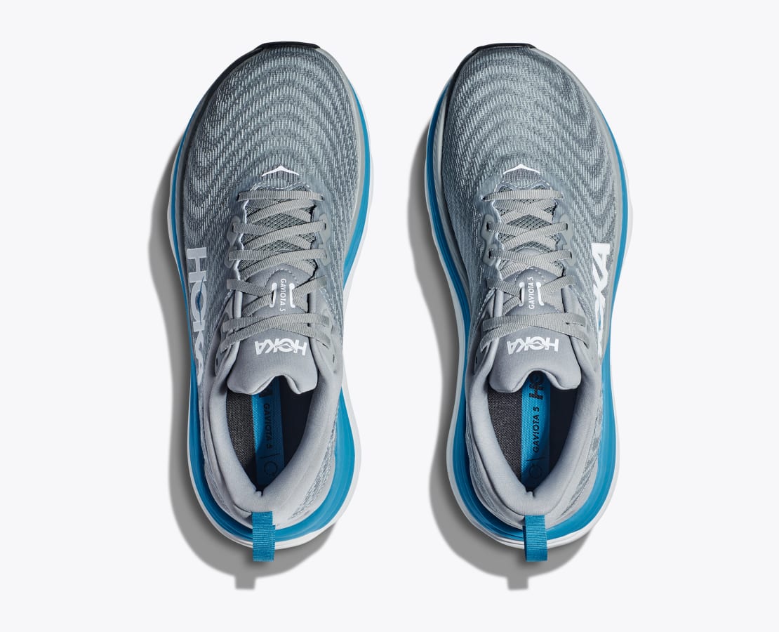 Hoka M Gaviota 5. Stabil och mycket dämpad springsko i herrmodell. Grå toner i färg med vita och blåa detaljer. Hos Hoka specialisterna i Sverige.