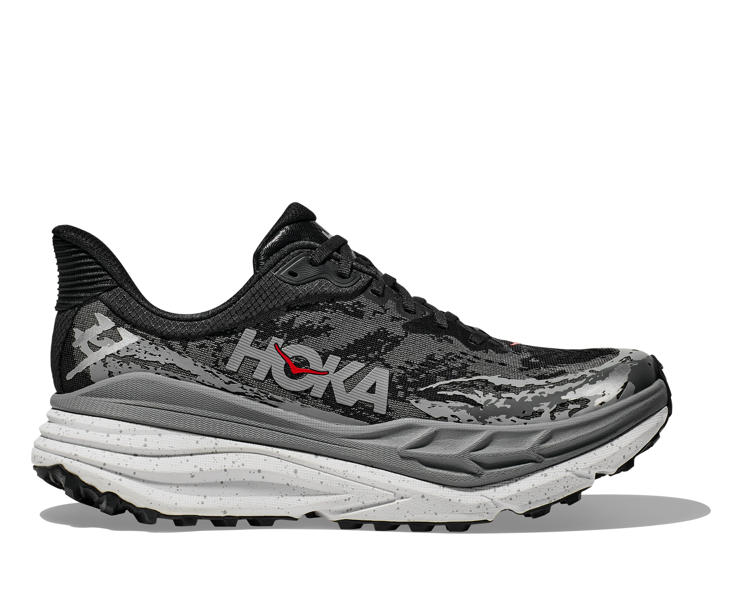 Hoka Stinson 7 M, herrmodell hybridsko för alla underlag. En av Hokas stabilaste skor med pronationsstöd. En väldämpad sko som avlastar rygg och knä. Här i svart, grått och vit med små röda detaljer.