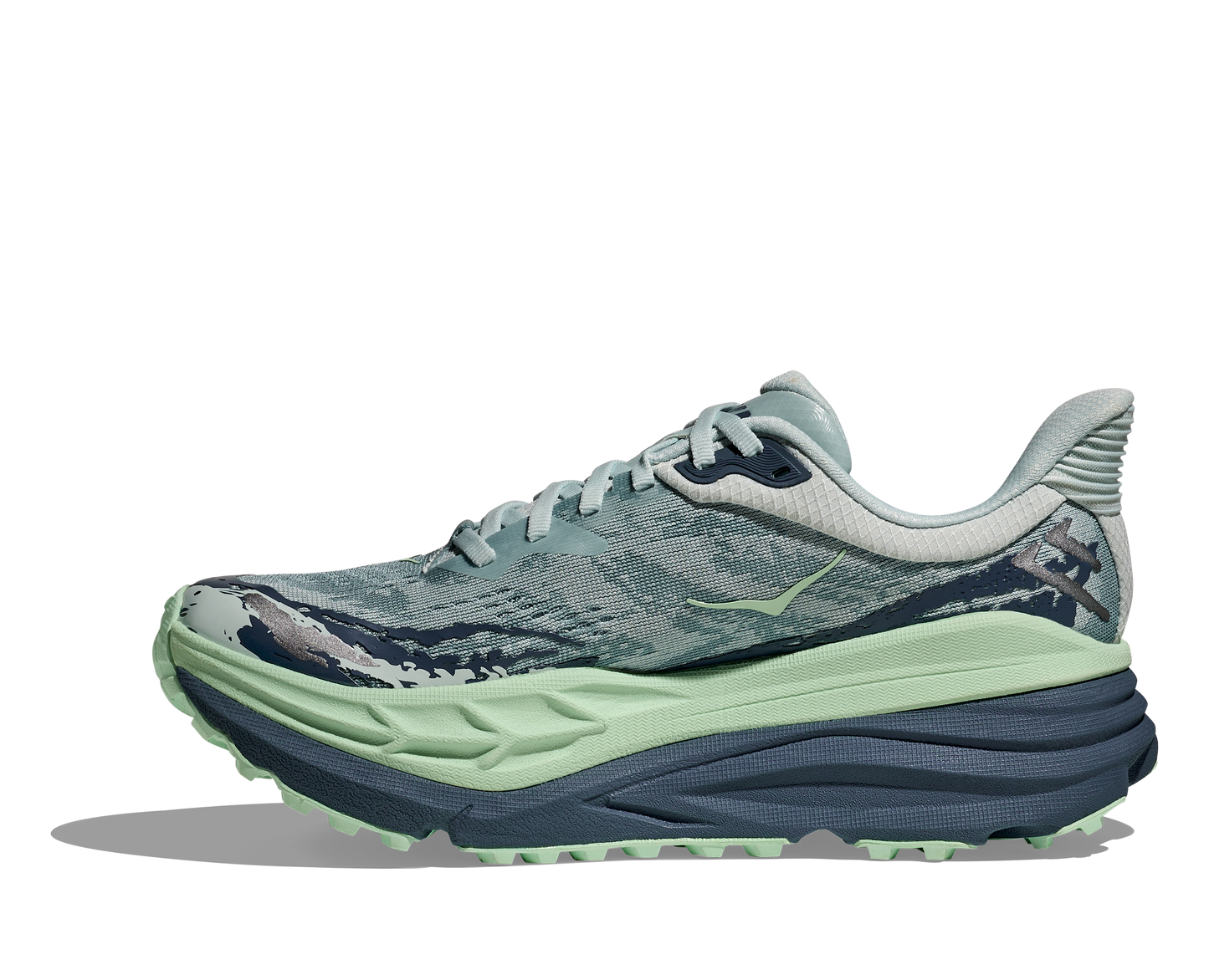 Hoka Stinson 7 W, dammodell hybridsko för alla underlag. En av Hokas stabilaste skor med pronationsstöd. En väldämpad sko som avlastar rygg och knä. Färg i nyanser av grönt och blått.