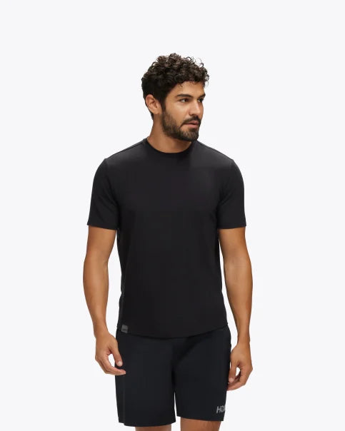 Extremt mjuk och bekväm T-Shirt i svart färg. Liten Hoka logo i mitten av skulderbladen i en grå färg. Denna tröja har en smal passform men den är inte tight.