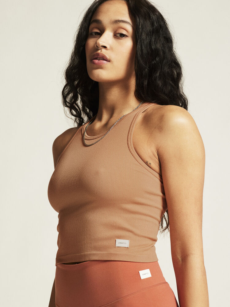 Craft Collective Rib Tank Top W. Sömnlös träningstopp i mjuk och ribbad kvalitet till dam. Kroppsnära passform och ribbad ytstruktur skapar skön och följsam känsla. Beige/brun nyans och med vit Craft etikett nedtill vänster fram.
