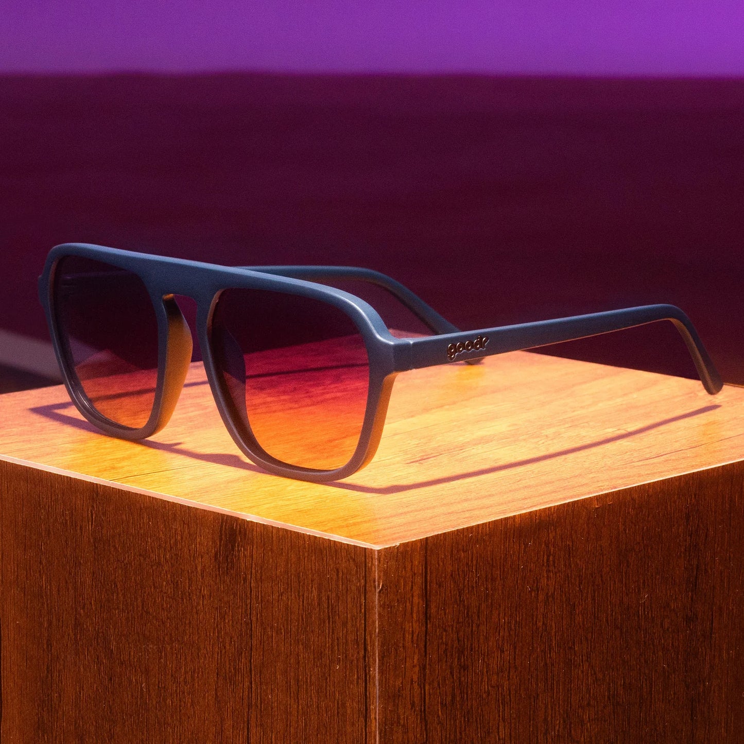 goodr Deja Vu Daydream. Fyrkantiga aviator-solglasögonen i mörkblå båge och lila gradientlinser. Dessa solglasögon kombinerar vintagekänsla med modern teknik och erbjuder både estetik och funktionalitet.