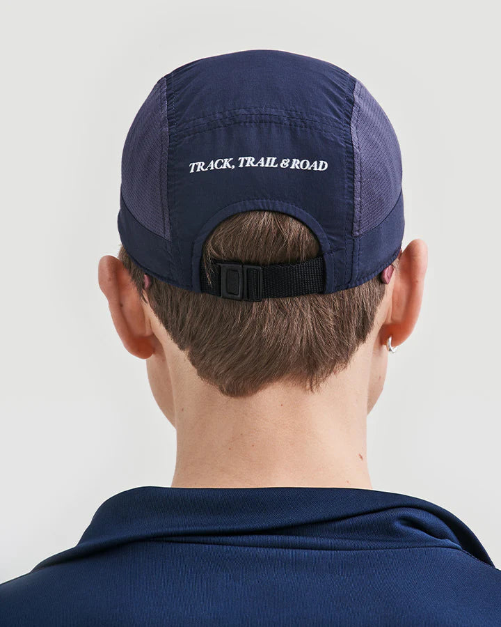 YMR Bäckaryd Performance Cap. Marinblå keps med meshpaneler på sidorna. Logotyp YMR Track Club framtill och text bak "TRACK, TRAIL & ROAD" i vita reflexdetaljer.