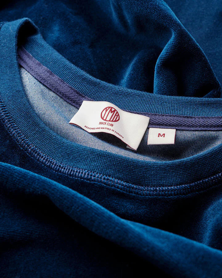Marinblå sweatshirt i plysch. Unisexplagg med avslappnad passform. Satinetikett på höger sida.