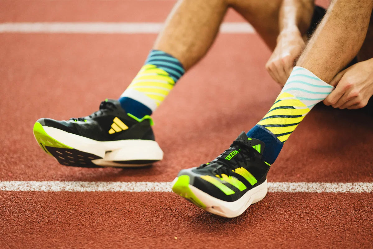 Incylence Running Diagonals Navy Canary. Löparstrumpa med perfekt passform. Blå i grunden med fräska detaljer i turkos, vitt och nylon/gult.