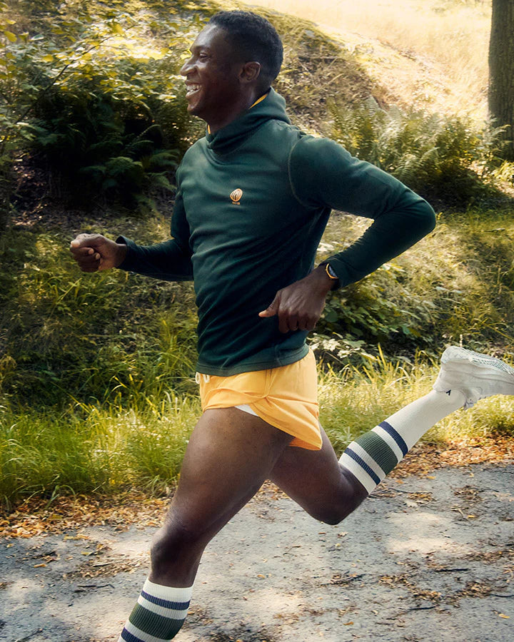 YMR Åsunden Men's Hoodie. Grön hoodie med gul kontrastfärg på insidan av luvan och loggan på bröstet. Huva med hög krage och tumöppningar i ärmsluten. Tight, sportig passform.