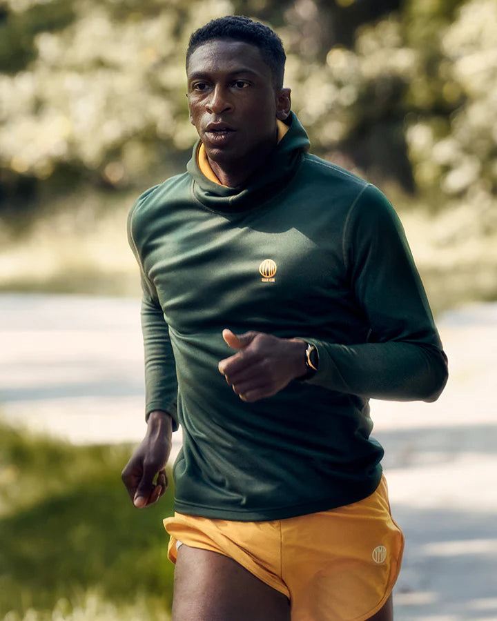 YMR Åsunden Men's Hoodie. Grön hoodie med gul kontrastfärg på insidan av luvan och loggan på bröstet. Huva med hög krage och tumöppningar i ärmsluten. Tight, sportig passform.