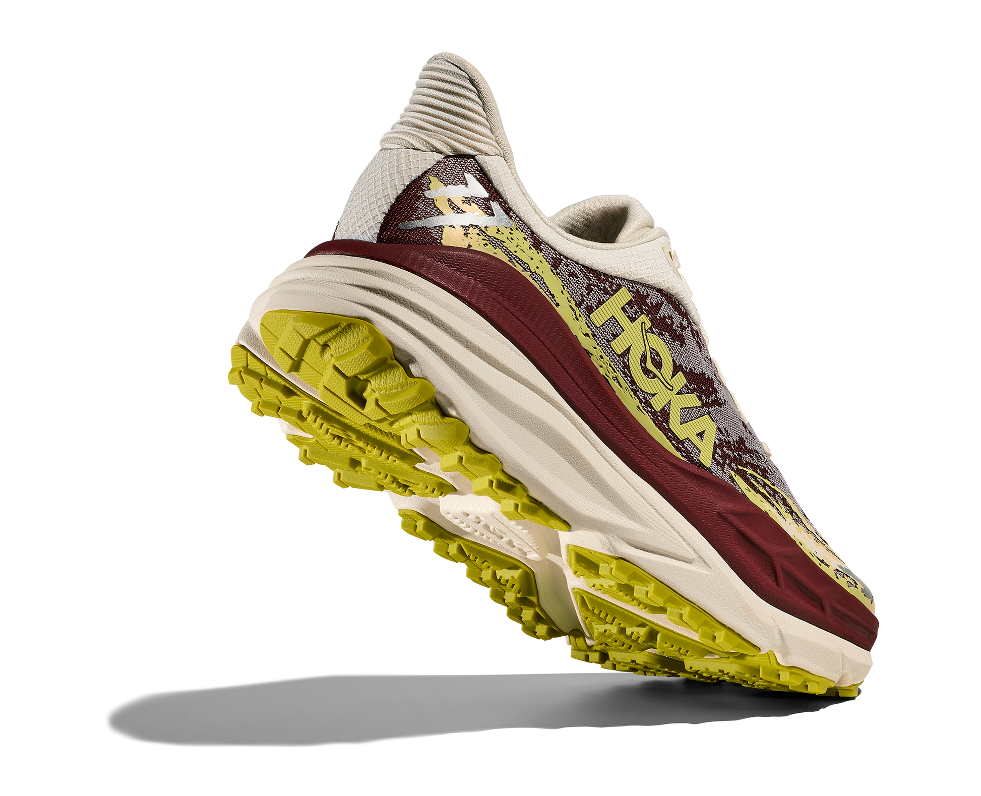 Hoka Stinson 7 W, dammodell. Hybridsko för alla underlag. En av Hokas stabilaste skor med pronationsstöd. En väldämpad sko som avlastar rygg och knä. Färgen här går i röda, gula och beiga nyanser. 