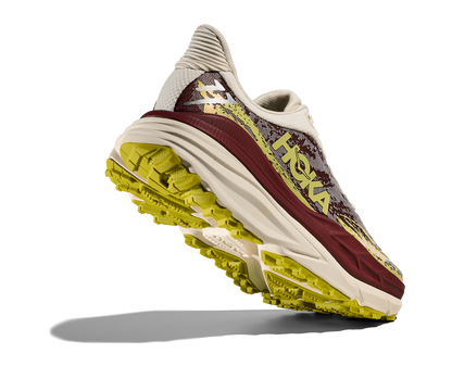 Hoka Stinson 7 W, dammodell. Hybridsko för alla underlag. En av Hokas stabilaste skor med pronationsstöd. En väldämpad sko som avlastar rygg och knä. Färgen här går i röda, gula och beiga nyanser. 