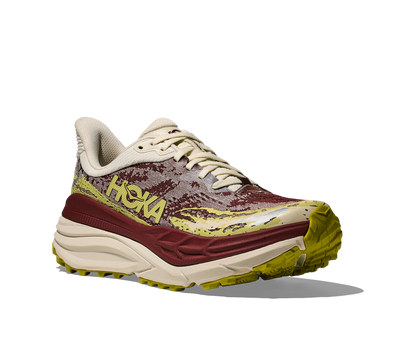 Hoka Stinson 7 W, dammodell. Hybridsko för alla underlag. En av Hokas stabilaste skor med pronationsstöd. En väldämpad sko som avlastar rygg och knä. Färgen här går i röda, gula och beiga nyanser. 