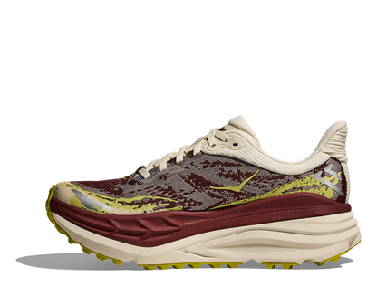 Hoka Stinson 7 W, dammodell. Hybridsko för alla underlag. En av Hokas stabilaste skor med pronationsstöd. En väldämpad sko som avlastar rygg och knä. Färgen här går i röda, gula och beiga nyanser. 