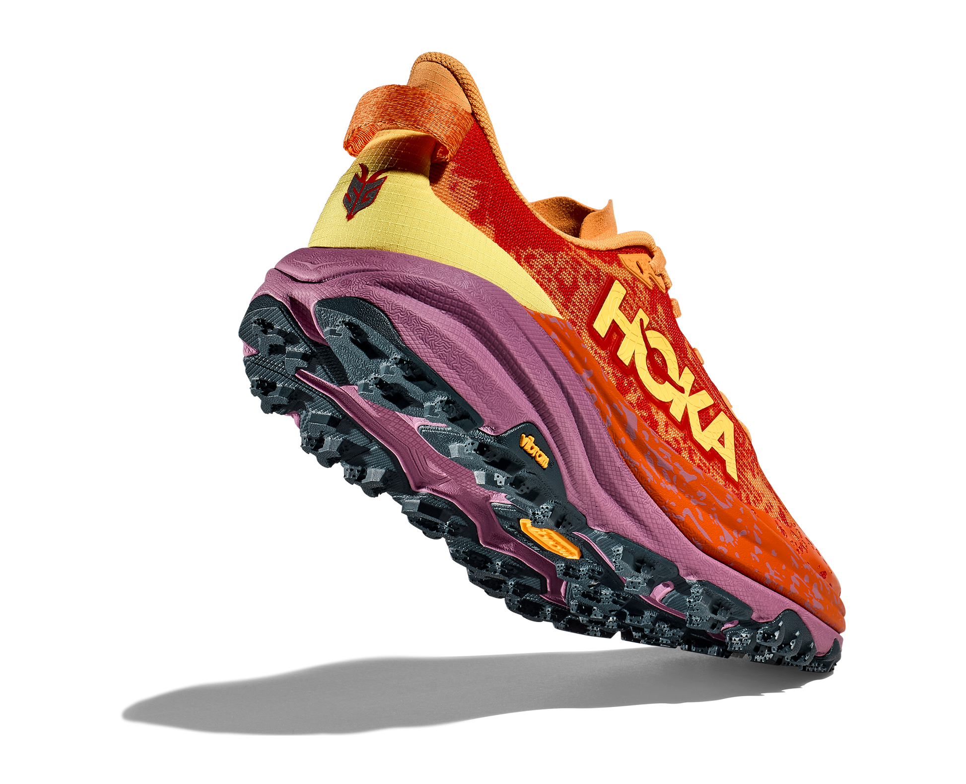 Hoka W Speedgoat 6. Terrängsko med vibram och dobbar. Röd och orange i färg. Dämpad och stabil.