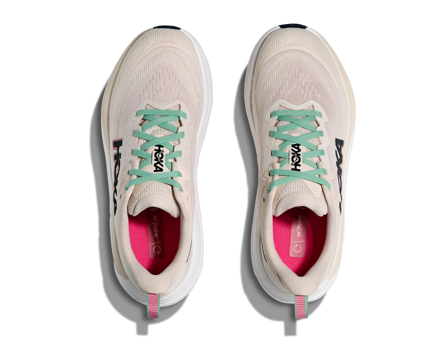 Hoka Skyflow W, löparskor i beige och vit färg med detaljer i rosa, grönt och svart. Dämpad och stabil sko som är gjord för asfalt och grusvägar. Köp hos oss, din Hoka specialist i Sverige!