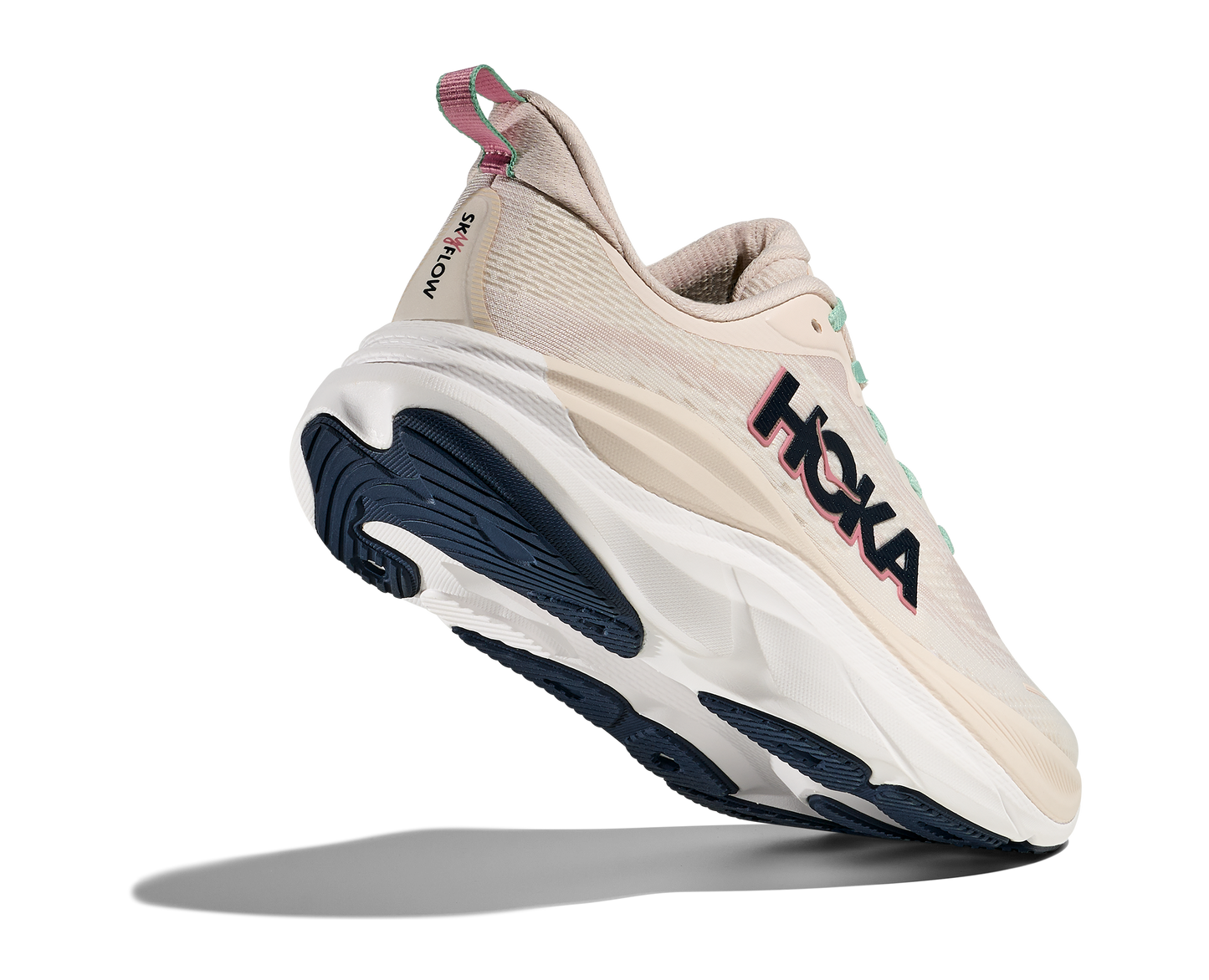 Hoka Skyflow W, löparskor i beige och vit färg med detaljer i rosa, grönt och svart. Dämpad och stabil sko som är gjord för asfalt och grusvägar. Köp hos oss, din Hoka specialist i Sverige!
