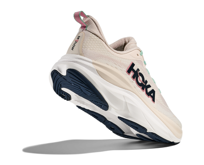 Hoka Skyflow W, löparskor i beige och vit färg med detaljer i rosa, grönt och svart. Dämpad och stabil sko som är gjord för asfalt och grusvägar. Köp hos oss, din Hoka specialist i Sverige!