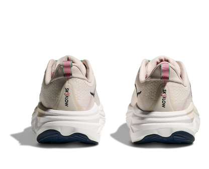 Hoka Skyflow W, löparskor i beige och vit färg med detaljer i rosa, grönt och svart. Dämpad och stabil sko som är gjord för asfalt och grusvägar. Köp hos oss, din Hoka specialist i Sverige!