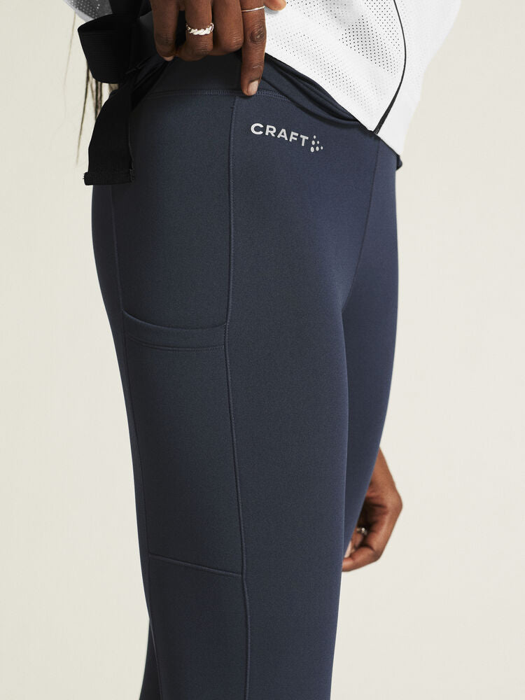 Craft ADV Essence High Waist Warm Tights. Mörkblå tights i dammodell med bred resår i midjan. Två stora ytterfickor på benen samt nyckelficka i midjan. 