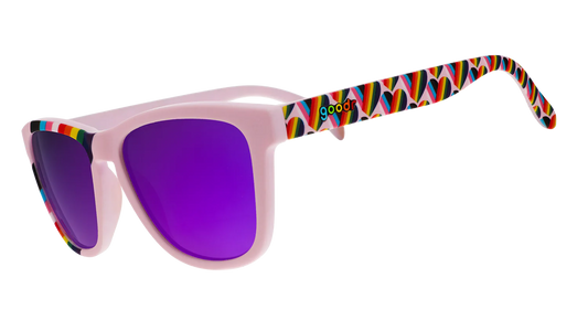 goodr We're Here to Slay. Exklusiva Pride-solglasögon från goodr med stilrena lavenderlila bågar med hjärtan i regnbågsfärger längst med bågarna och en regnbågsflagga över ena bågen, spegelblanka lilla linser. Passform Medium - perfekt för normalstora ansikten. Spegelreflekterande linser som minskar bländning och skyddar ögonen. 