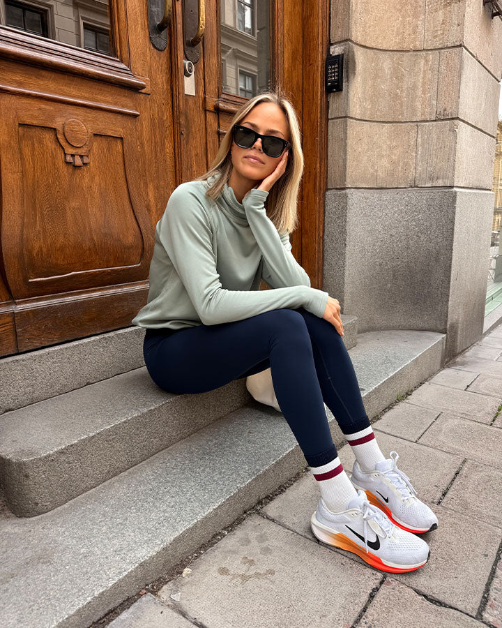 YMR Åsunden Ladies Funnel Neck Mint. Ljusgrön mångsidig och mjuk tröja med mörkblått inuti den höga kragen och på logotyp på bröstet. Dragsko i både kragen och i midjan för justerbar passform. Reflexdetalj på nedre delen av ryggen. 