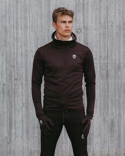 YMR Åsunden Men's Hoodie. Hoodie i rödbrun nyans med beige kontrastfärg på insidan av luvan och på loggan på bröstet. Huva med hög krage och tumöppningar i ärmsluten. Tight, sportig passform. 