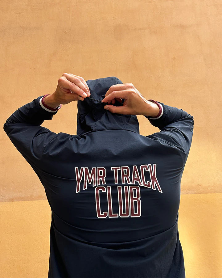 Vind- och vattenavvisande mörkblå löparjacka för herr med huva och ventilation.
Ventilation i stickad mesh under armarna, dragskojusterbar huva som kan rullas in i kragen, samt dragkedjeförsedda sidfickor för förvaring. Jackan pryds av YMR:s logotyp i off-white framtill och ett reflexprint i svanken för ökad synlighet i mörker. Logga i Offwhite och vinrött på ryggen. Mudd i ärmslut i vitt och vinrött. 